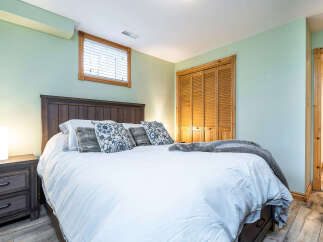 This inviting bedroom boasts a cozy atmosphere with its warm wooden accents and soft, neutral color palette.