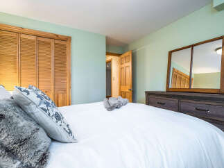 Step into this inviting bedroom, featuring a cozy bed adorned with plush pillows and a soft comforter.