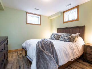 This cozy bedroom features a comfortable bed with a plush throw and decorative pillows, creating a relaxing atmosphere.