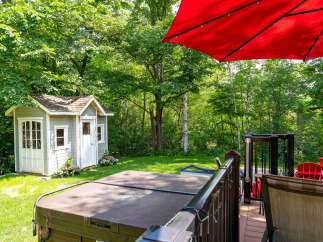 Escape to your own private oasis with this stunning property! Enjoy the tranquility of a lush backyard featuring a charming shed and a relaxing hot tub.