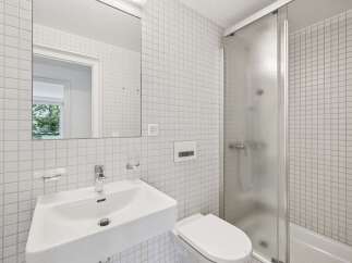This modern bathroom features a sleek, minimalist design with white square tiles covering the walls.