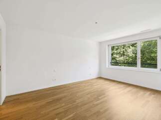This bright and airy room features beautiful hardwood floors and crisp white walls, creating a clean and modern aesthetic.