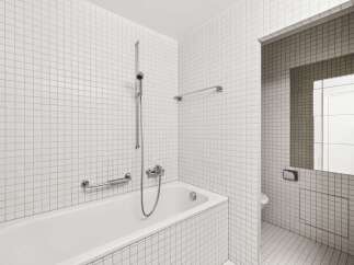 This modern bathroom features a sleek, minimalist design with pristine white tiles covering the walls and floor.