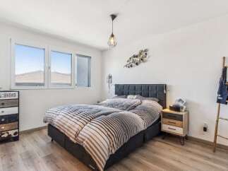 This cozy bedroom features a comfortable bed with stylish bedding, perfect for a relaxing retreat.