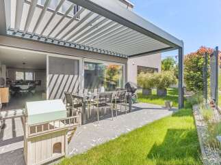 Enjoy outdoor living at its finest with this stunning property featuring a modern patio and a sleek pergola.