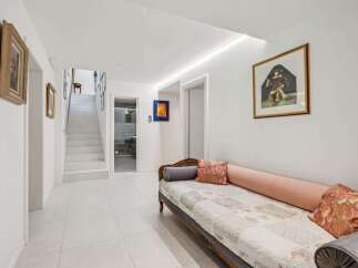 Step into this elegant hallway, featuring pristine white walls and a stunning staircase.