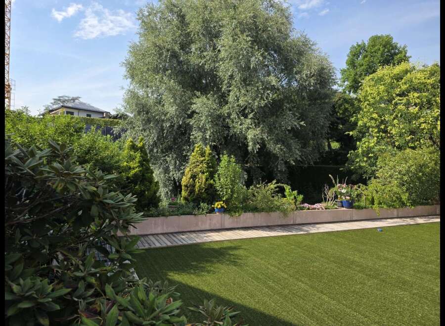 Experience outdoor living at its finest with this beautifully landscaped garden, featuring a lush green lawn perfect for recreation and relaxation.