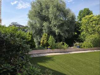 Experience outdoor living at its finest with this beautifully landscaped garden, featuring a lush green lawn perfect for recreation and relaxation.