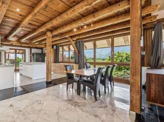 Experience luxury living in this stunning property featuring a spacious dining area with a wooden ceiling and large windows.