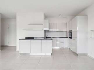 Discover modern living in this stunning property featuring a sleek, all-white kitchen.
