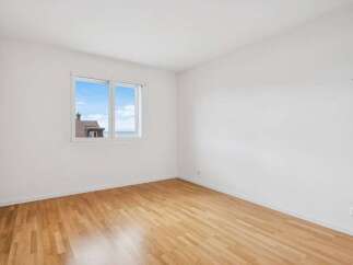 This bright and airy room features beautiful hardwood floors and crisp white walls, creating a clean and inviting atmosphere.