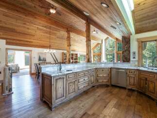 Experience rustic elegance in this stunning kitchen! Featuring custom wood cabinetry, granite countertops, and high-end appliances, this space is perfect for both cooking and entertaining.