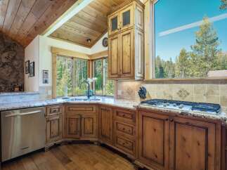 This stunning kitchen boasts custom cabinetry, granite countertops, and stainless steel appliances.