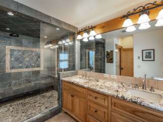 Step into luxury with this stunning bathroom featuring a spacious walk-in shower with a built-in bench and elegant tile work.