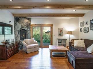 This stunning living space features a cozy stone fireplace, perfect for those chilly evenings.