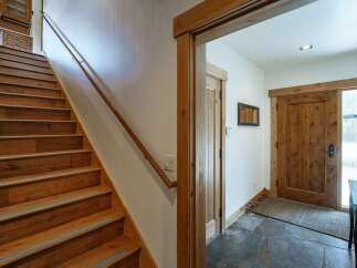 This stunning property boasts a beautifully crafted staircase with rich wooden steps and a sleek handrail, creating a warm and inviting atmosphere.