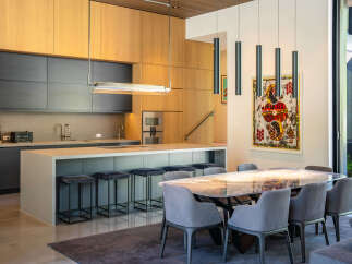This stunning modern kitchen and dining area boasts sleek design and high-end finishes.