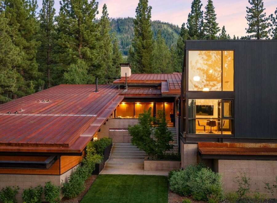 Experience modern mountain living in this stunning architectural home, nestled amidst towering pine trees and overlooking a picturesque hillside.