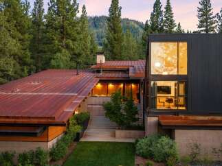 Experience modern mountain living in this stunning architectural home, nestled amidst towering pine trees and overlooking a picturesque hillside.