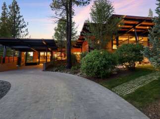 Experience modern luxury with this stunning architectural home, featuring a dramatic cantilevered roof and expansive glass windows that seamlessly blend indoor and outdoor living.