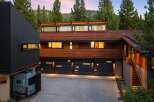 Experience modern luxury in this stunning mountain home, featuring a striking dark facade and warm wood accents.