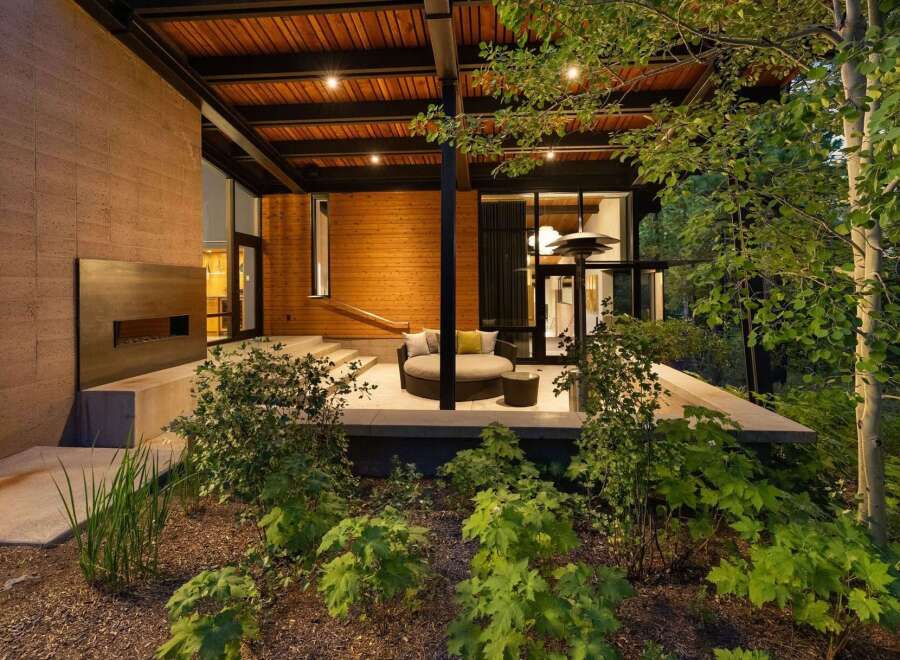 Experience modern luxury with this stunning outdoor living space, featuring a sleek fireplace and comfortable circular seating.