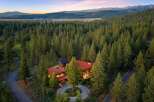 Nestled amidst a dense forest of towering pine trees, this stunning modern home offers a serene retreat with breathtaking mountain views.
