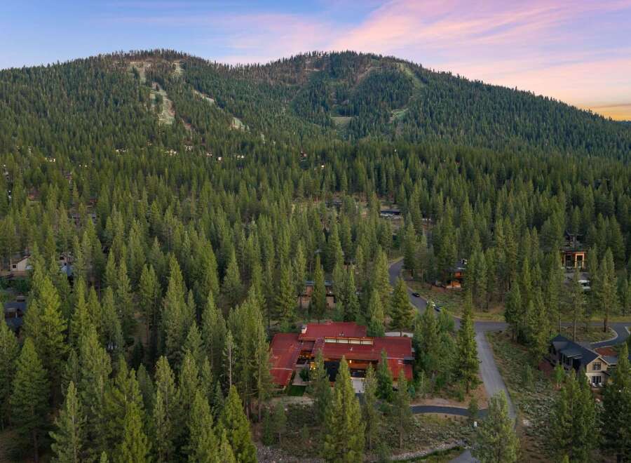 Nestled amidst a dense forest of towering pine trees, this stunning modern home offers a serene mountain retreat.