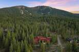 Nestled amidst a dense forest of towering pine trees, this stunning modern home offers a serene mountain retreat.