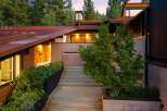 Experience modern mountain living with this stunning architectural home, featuring a striking rusted metal roof and natural wood accents.