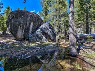 Discover the tranquility of nature in this stunning landscape featuring massive granite boulders.