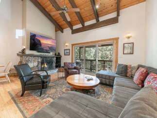 This stunning living room boasts a cozy fireplace and a large flat-screen TV, perfect for relaxing evenings.
