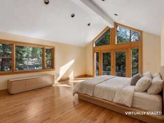Experience the epitome of luxury in this stunning bedroom, featuring expansive windows that frame breathtaking views of the surrounding nature.