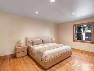This beautifully staged bedroom offers a serene retreat with its neutral color palette and natural wood flooring.