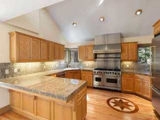 This stunning kitchen boasts custom cabinetry, granite countertops, and top-of-the-line stainless steel appliances.