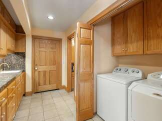 Step into this beautifully designed laundry room, featuring ample storage with custom cabinetry.