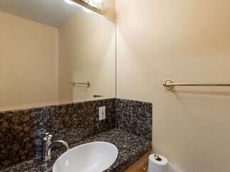 This stunning bathroom features a sleek granite countertop and a modern sink, perfect for a luxurious touch.