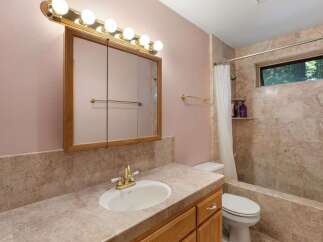 This bathroom features a stylish vanity with a sink and a large mirror, perfect for daily routines.