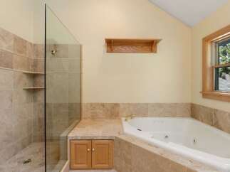 This luxurious bathroom features a spacious walk-in shower with glass doors and elegant tile work.