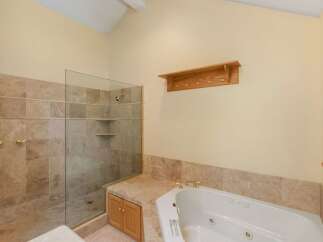 Step into luxury with this stunning bathroom featuring a spacious walk-in shower with glass doors and elegant tile work.