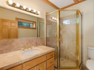 Step into luxury with this stunning bathroom! Featuring a sleek glass shower enclosure with gold accents, a stylish vanity, and a large mirror, this space is designed for both functionality and elegance.