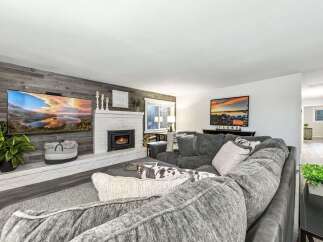 Experience luxury living in this stunning property featuring a cozy fireplace and a modern entertainment setup.