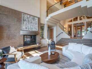 Step into luxury with this stunning property featuring a modern living room with a fireplace and a cozy seating area.