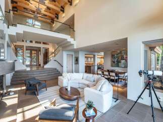 This stunning property boasts a grand entrance with a staircase leading to a second-floor balcony.