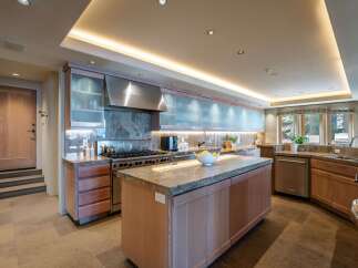 This stunning kitchen boasts high-end appliances, including a professional-grade range and a sleek stainless steel hood.