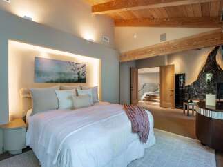 This luxurious bedroom showcases a stunning blend of modern and rustic design elements.