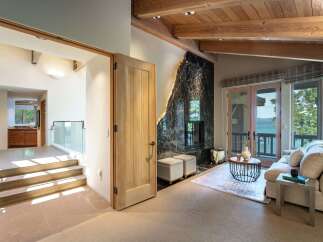 Step into luxury with this stunning property featuring a unique black marble fireplace and elegant wooden beams.
