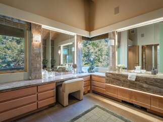 This luxurious bathroom boasts a stunning vanity area with ample storage and a beautiful stone countertop.