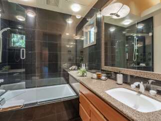Step into luxury with this stunning bathroom! Featuring sleek black tile, a modern glass shower, and a beautiful vanity with a granite countertop, this space is designed for relaxation and style.