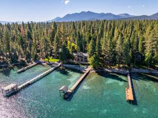 Discover a stunning lakeside property nestled amidst towering trees.